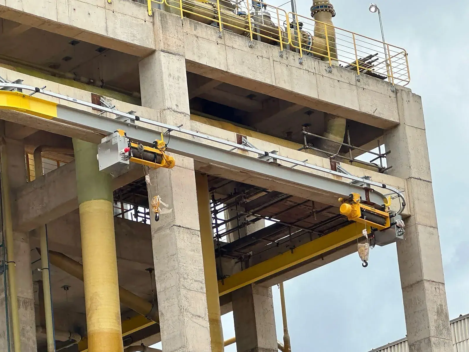 Close da monovia com duas talhas elétricas de cabo de aço na estrutura da planta